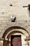 Sundial working. Medieval romanesque San Pedro Church, stone wall and arched door. Allariz, Orense, Spain.