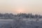 Sundown and sunrises. Winter landscape. Dark sky and silhouettes of trees on the background of heaven. Frosty evening, snow around