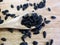 Sunflower Black Seeds in Wooden Spoon and Table Close Up