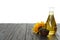Sunflower, bottle of oil and seeds on black wooden table against white background, space for text