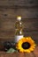 Sunflower cooking oil, seeds and yellow flower on wooden table