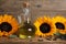 Sunflower cooking oil, seeds and yellow flowers on wooden table