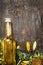 Sunflower oil in glass bottle and sunflowers on rustic wooden background