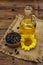 Sunflower oil in glass cruet with flower head and seeds in wooden bowl