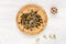 Sunflower and pumpkin seeds lie on a round wooden plate, next to garlic cloves on a white wooden background. Organic healthy,