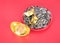 Sunflower seeds and gold ingots in the plate on red background.The Chinese characters in the picture mean and `Attracting Wealth`