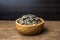 Sunflower seeds group with a wooden cup on wood background. The name of science : Helianthus annuus