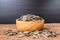 Sunflower seeds group with a wooden cup on wood background. The name of science : Helianthus annuus