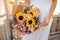Sunflower wedding bouquet in the hands of the bride