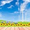 Sunflowers with wind turbine and solar panels on green grass fie