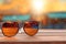 A sunglass on wooden board on blur beach with bokeh background