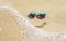 Sunglasses with flag of Bulgaria on a sandy beach. Nearby is a sea lightning and a painted smile.