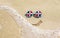 Sunglasses with flag of Dominican Republic on a sandy beach. Nearby is a sea lightning and a painted smile.