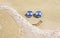 Sunglasses with flag of Israel on a sandy beach. Nearby is a sea lightning and a painted smile.