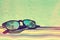 Sunglasses with palm trees reflections on a bath towel, summer concept