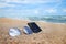 Sunglasses and phone are placed on beach and reflections of bright sky