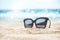 Sunglasses placed on the sandy beach