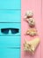 Sunglasses, seashells on blue pink wooden boards.