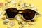 Sunglasses, shells and pebbles closeup on white background