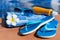 Sunglasses sunscreen cream blue slippers and towel on border of