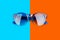 Sunglasses vibrant blue and orange red background closeup top view, fashionable sunshades colorful backdrop, trendy eyeglasses