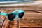 Sunglasses on wooden desk at the summer