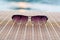 Sunglasses on wooden table and river (vintage background)