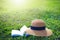 Sunhat and book lying on a lush green garden lawn under the hot rays of the sun