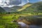 Sunken paddle boats in Lough Gummeenduff with warm sunlight on hills in Black Valley