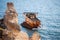 Sunken rusty cargo ship in still blue sea waters with rocks around