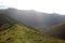Sunlight on grassy mountain ridge footpath Cumbria