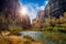 Sunlight peering out from behind an enormous cliff in Zion.