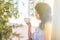 Sunlight in the photo, noise. A girl in profile sits in a cafe on the street and drinks tea