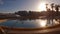 Sunlight reflecting in swimming pool water, mediterranean city in background