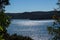 Sunlight on river against headland and blue sky