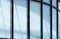 Sunlight and shadow on surface of curve glass building wall with white sunshade inside the office room