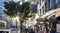 Sunlight shines on busy crowds of people walking down the sidewalk on 23rd Street through New York City