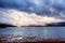 Sunlight through storm clouds over a Scottish Loch