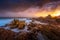 Sunlight through storm clouds on a rocky craggy coastal landscape