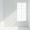 Sunlight streams into pristine white room from large window