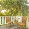 Sunlit balcony with wooven chairs and table