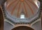 Sunlit church dome with balcony and stained glass windows