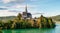 Sunlit church in the village of Maria Worth on the shores of Lake Worthersee in the Austrian mountains. Lake with clear clear wate