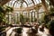 A sunlit conservatory with a wall of arched windows, intricate wrought-iron furniture