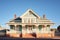 sunlit facade of a colonial revival house against a clear sky