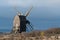 Sunlit grey old wooden windmill