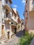 Sunlit narrow hill street in Nice, France.