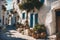 sunlit narrow traditional greek town street with ancient white houses in summer sunlight