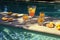sunlit pool with floating tom collins garnishes
