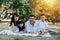 Sunlit portrait of an asian family in white clothes having picnic in a park